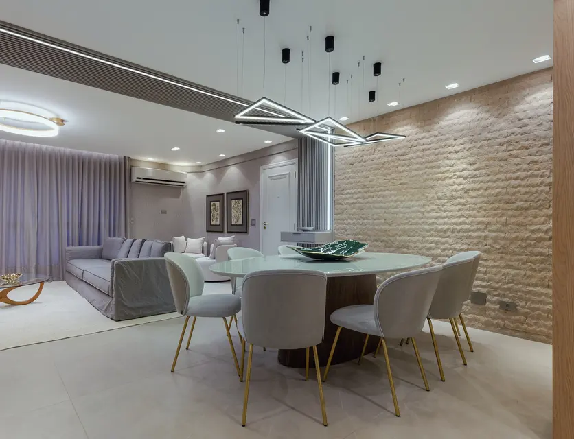 Sala de estar com painel de TV e mesa de jantar